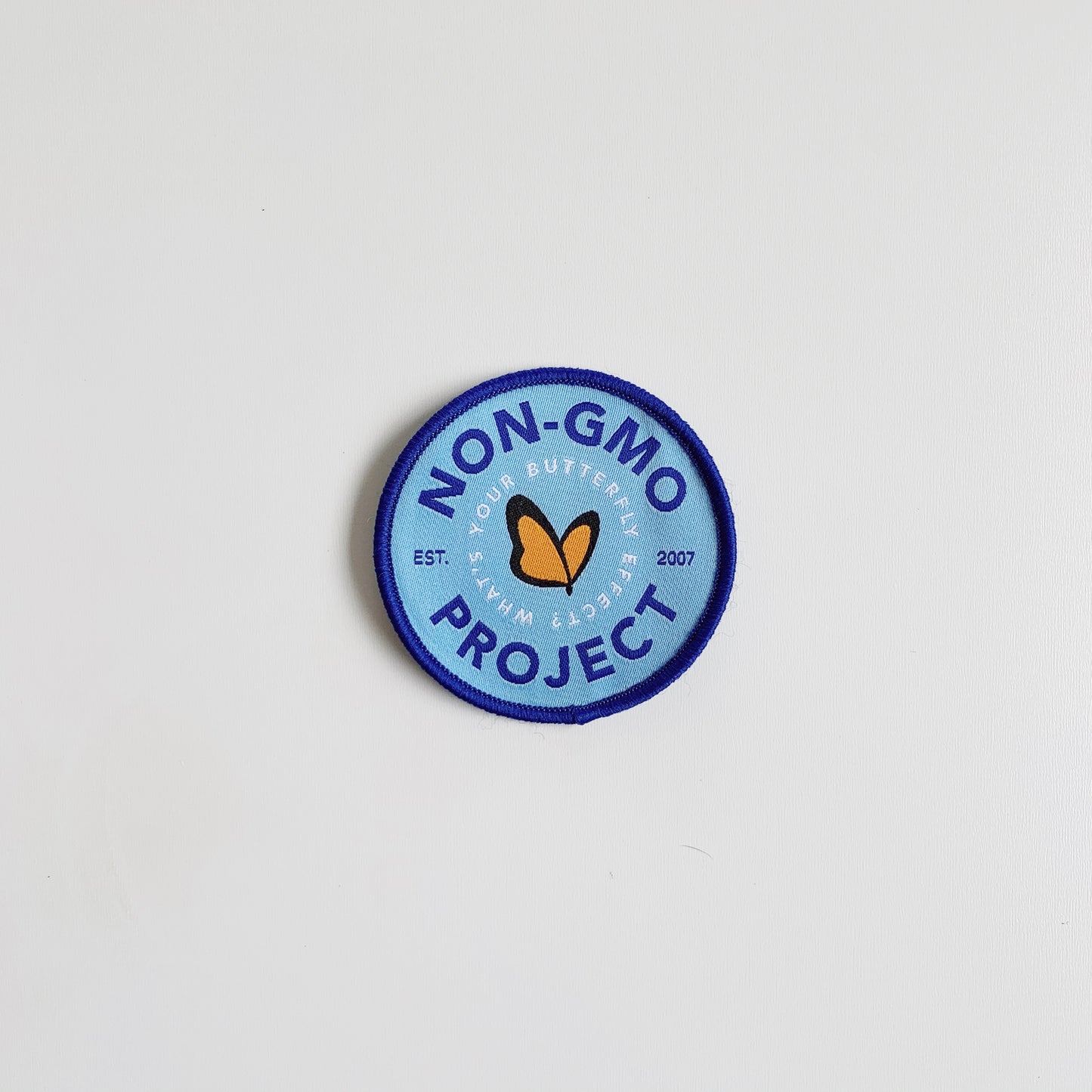 Single Non-GMO Project patch in navy, light blue, and orange